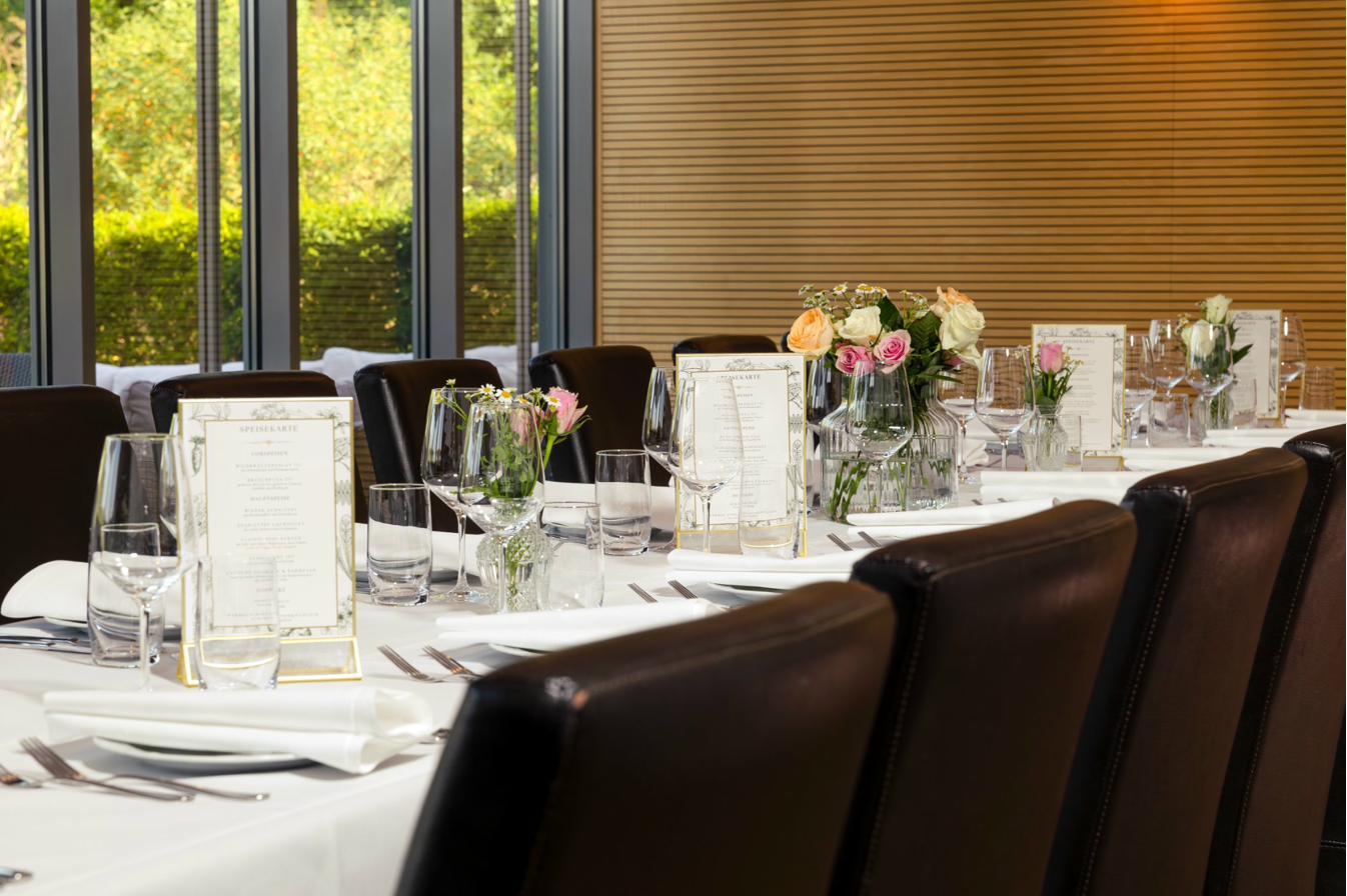 Gedeckte Tafel mit Blick ins Grüne und Blumendekoration