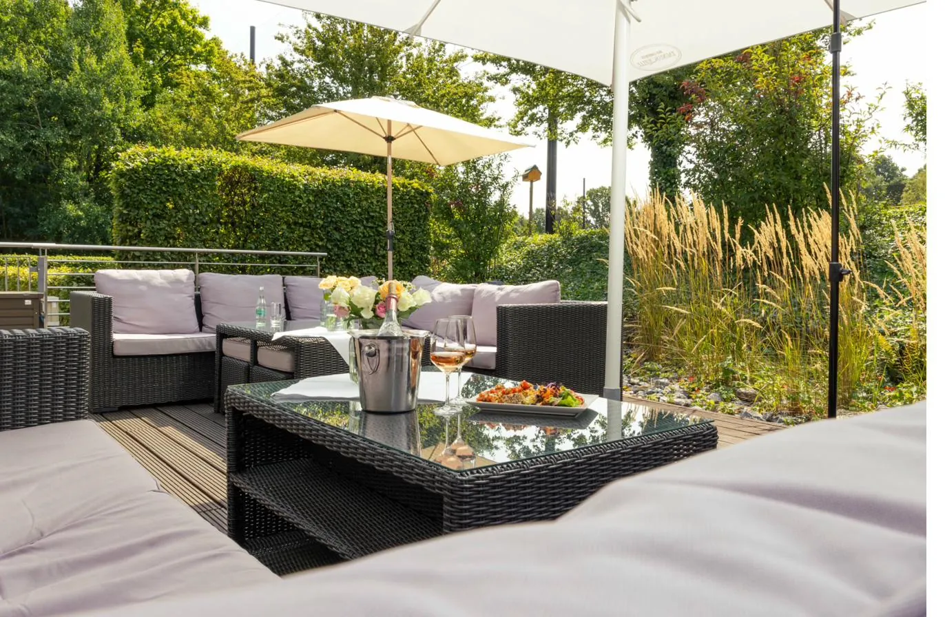 Abendstimmung auf der Panoramaterrasse im Passions Restaurant Bad Homburg &ndash; warmes Licht, gedeckte Tische, Sonnenuntergangs-Blick &uuml;ber den Royal Homburger Golf Club